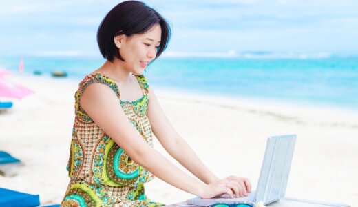 南国の海でノートパソコンを使う女性